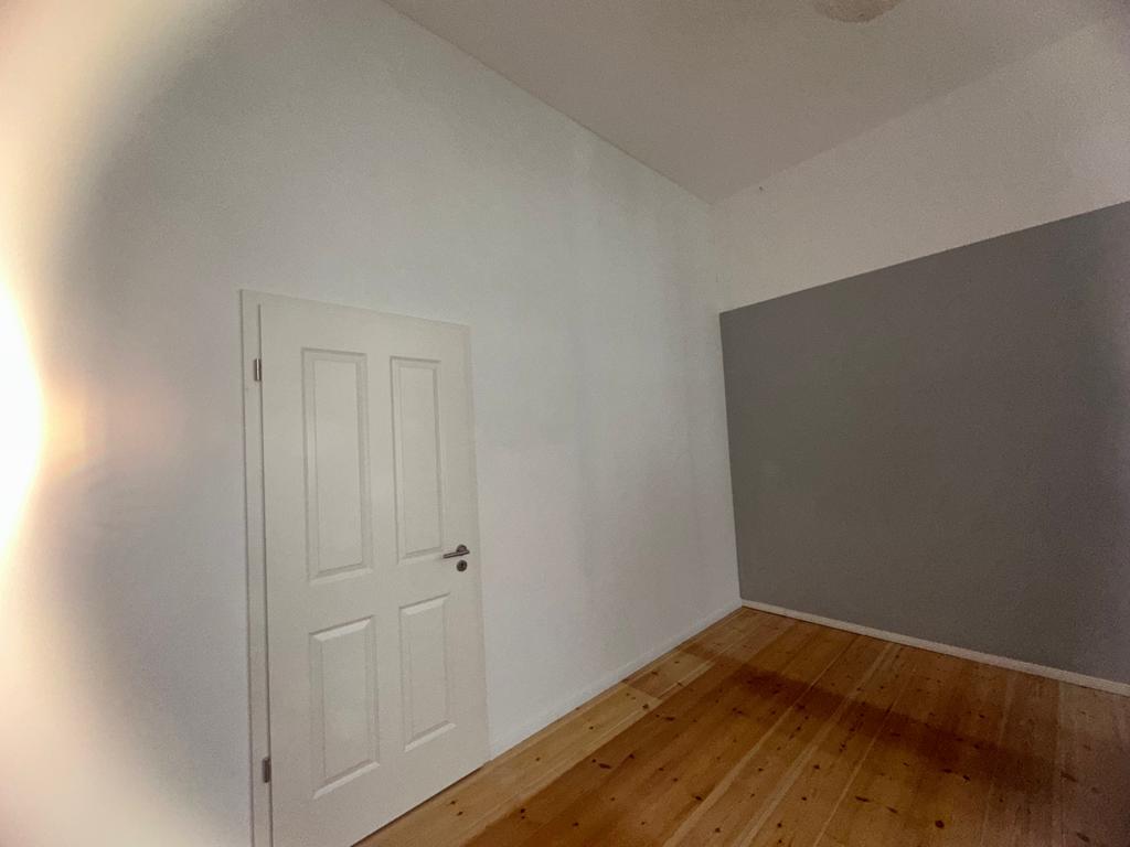 Fertige weiße Trockenbauwand mit Türöffnung und Sockelleiste in Berliner Altbauwohnung