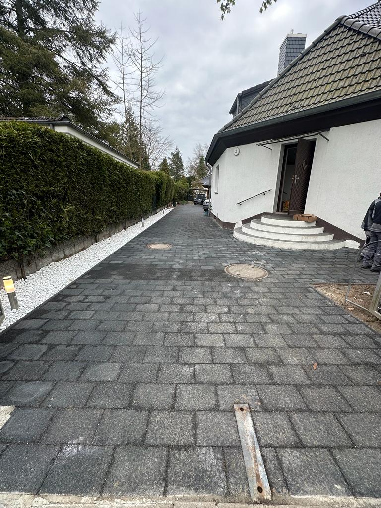 Gepflasterte Hofeinfahrt mit Betonsteinpflaster, Randsteinen und Zierkies in Berlin