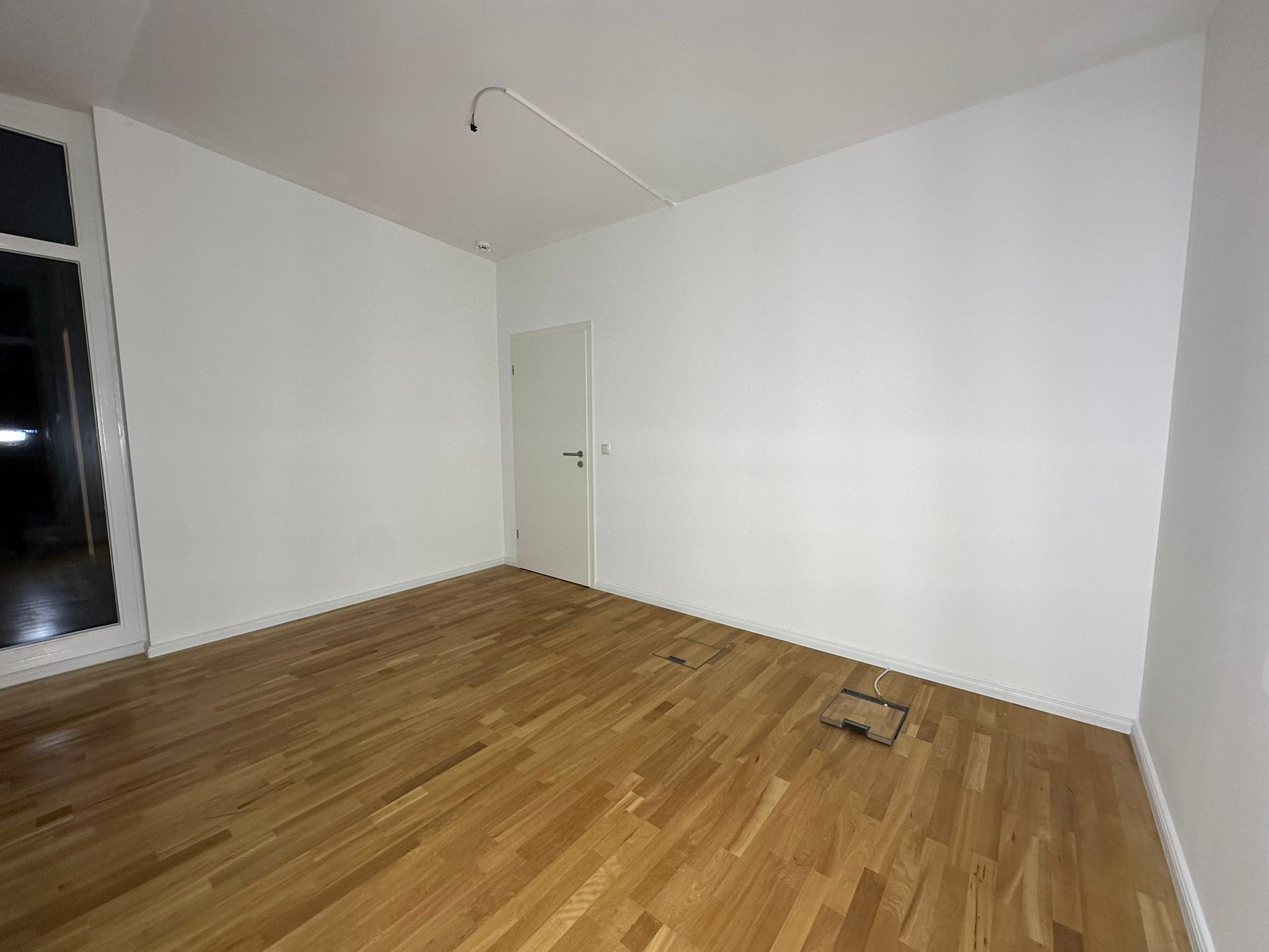 Fertig renovierter Raum mit Parkett und weißen Wänden