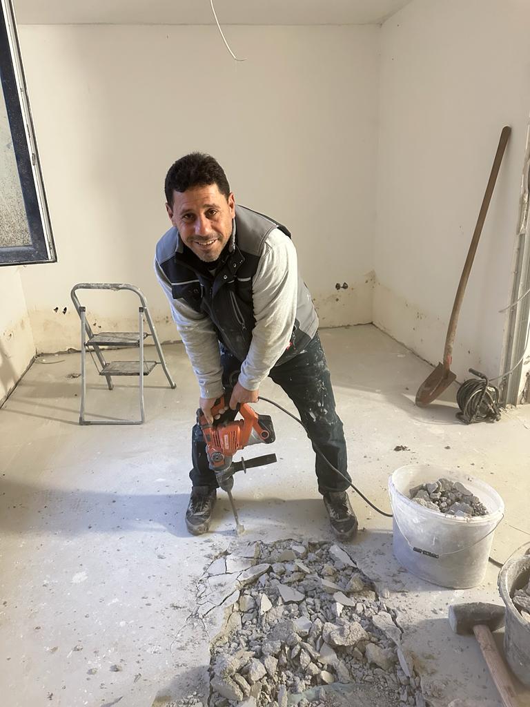 Inhaber von Falax-Bau stemmt mit dem Bohrhammer den Bodenaufbau auf